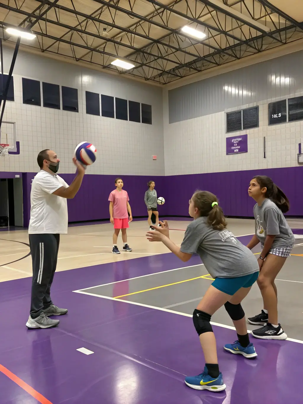 A volleyball team practicing serves and volleys in the school's indoor court, emphasizing precision and communication.