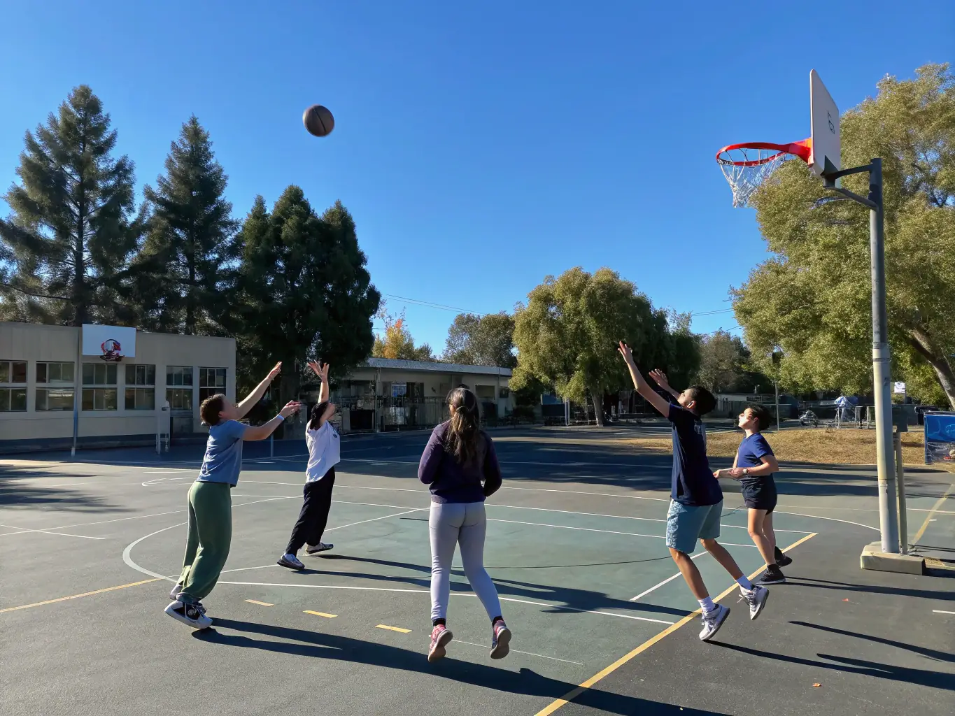 A group of students participating in a volleyball game, demonstrating teamwork and communication.