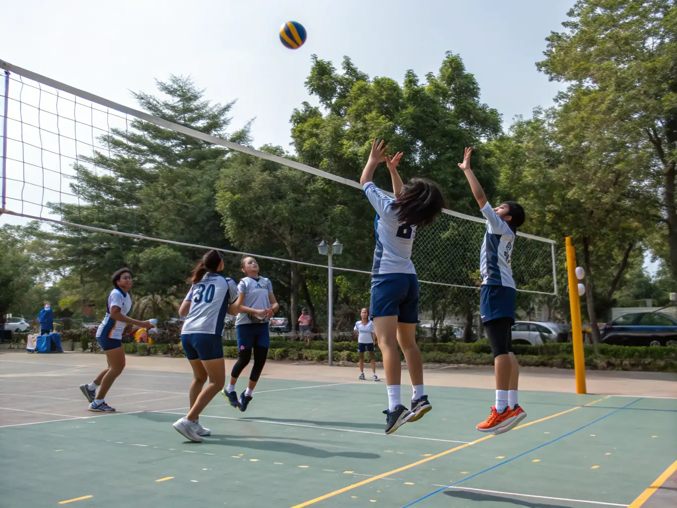 Students engaged in a volleyball match, demonstrating agility, coordination, and competitive spirit.